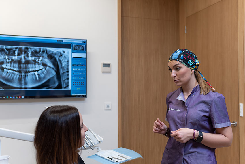 Natalia Gonzalez, nuestra dentista, explicando un tratamiento de carillas de composite a una chica.